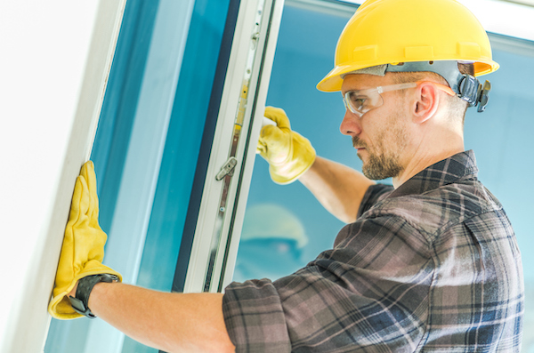 A professional working on replacing a window. Many homeowners ask themselves, should I tip window installers?