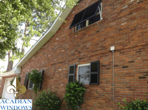 A brick house in Slidell with hurricane shutters from Acadian Windows