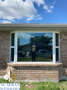 Our Vinyl Windows Fairhope Company represented by a photo of window on a brick building with the Acadian Windows logo.
