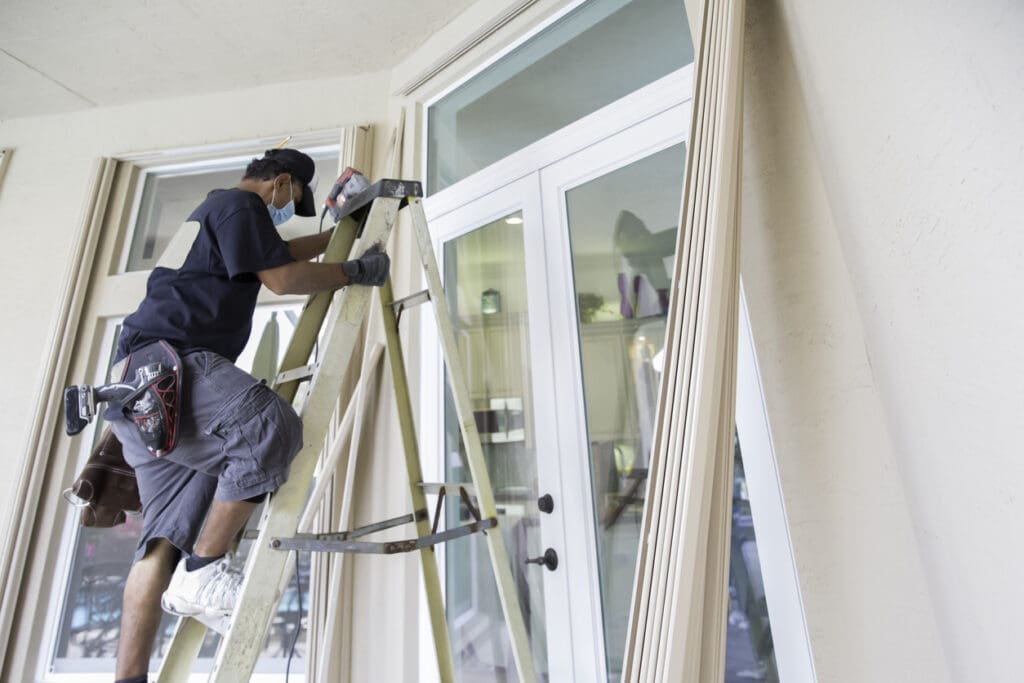 Contractor installing hurricane shutters. rr