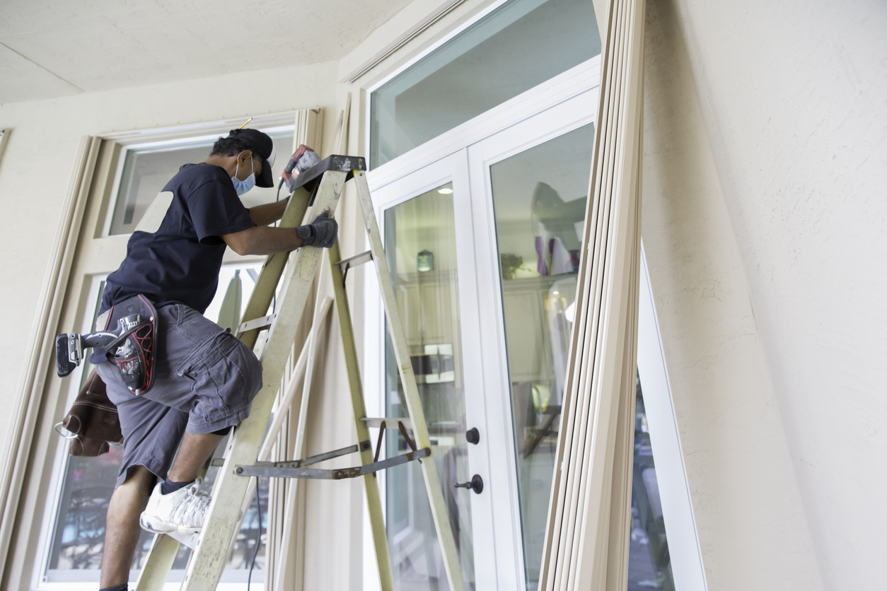 Contractor installing hurricane shutters. rr