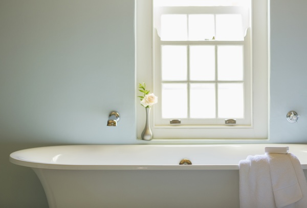 Soaking tub below window in luxury bathroom where homeowners need bathroom window ideas for privacy