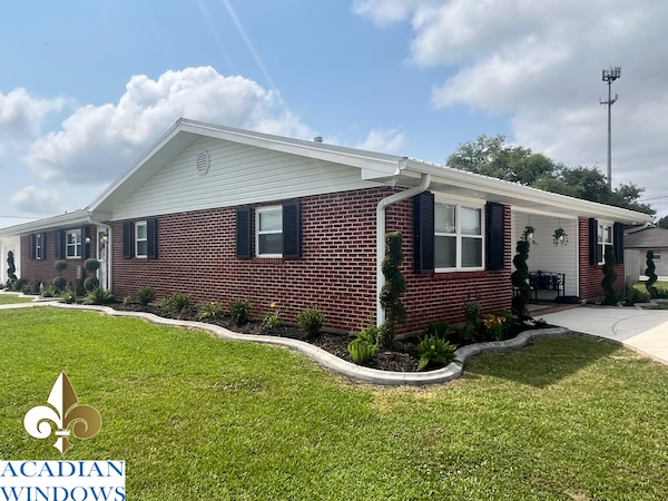 A real Acadian Windows customer example of hurricane shutters in Luling on a neat brick house